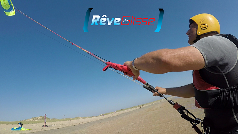 Stage kitesurf Morbihan. Pilotage d'une aile de kite à l'école kitesurf Quiberon Rêve de Glisse. Cours de kitesurf débutant sur la plage. L'élève pilote son aile. Il porte tout l'équipement dont le casque et le gilet pour aller naviguer dans la mer.